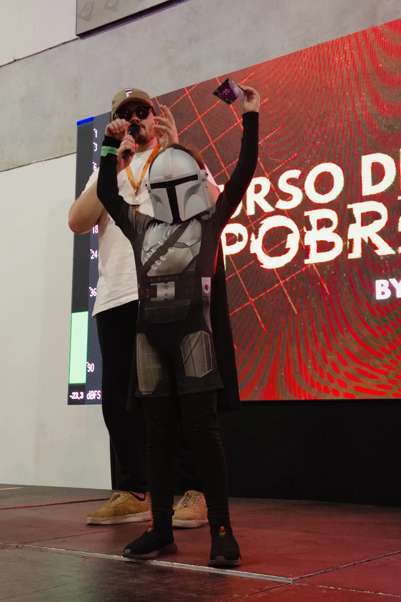 Apresentador do Posers Podcast anunciando o Cospobre no palco